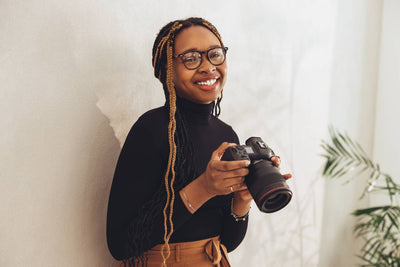 A happy photographer, smiling and holding her camera.